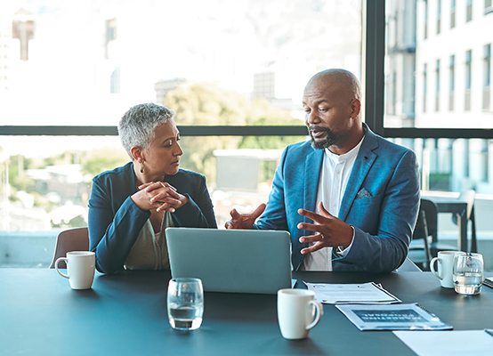 Business, presentation and man on a laptop in a corporate conference or office collaboration with a woman at work. Businessman, manager or coach for marketing, strategy and sales working with CEO.